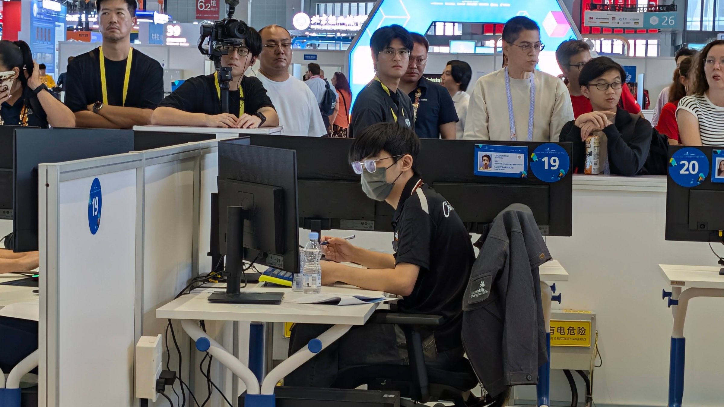 在上海的比賽工作站前作答，後方有觀眾觀看